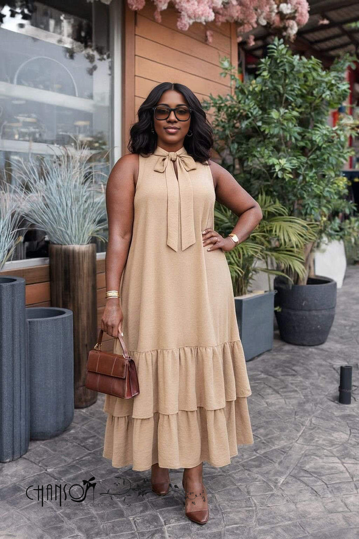 Tan sleeveless maxi dress with bow neckline and tiered ruffle hem