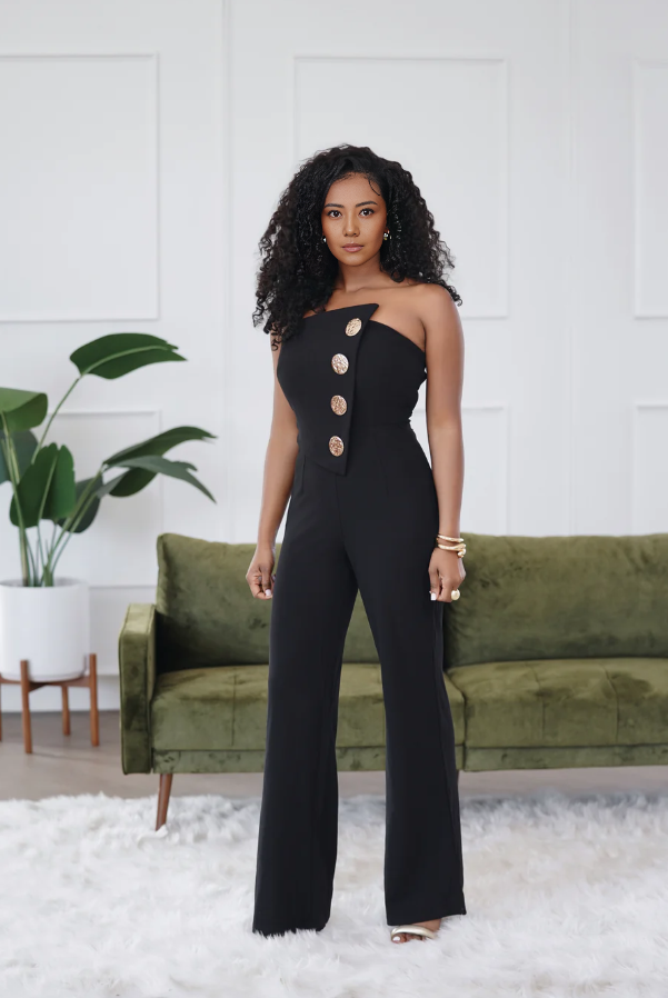 Black one-shoulder jumpsuit with fitted waist and round button detail, wide-leg