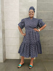 Navy midi dress with short ruffled sleeves and tiered skirt, small white pattern