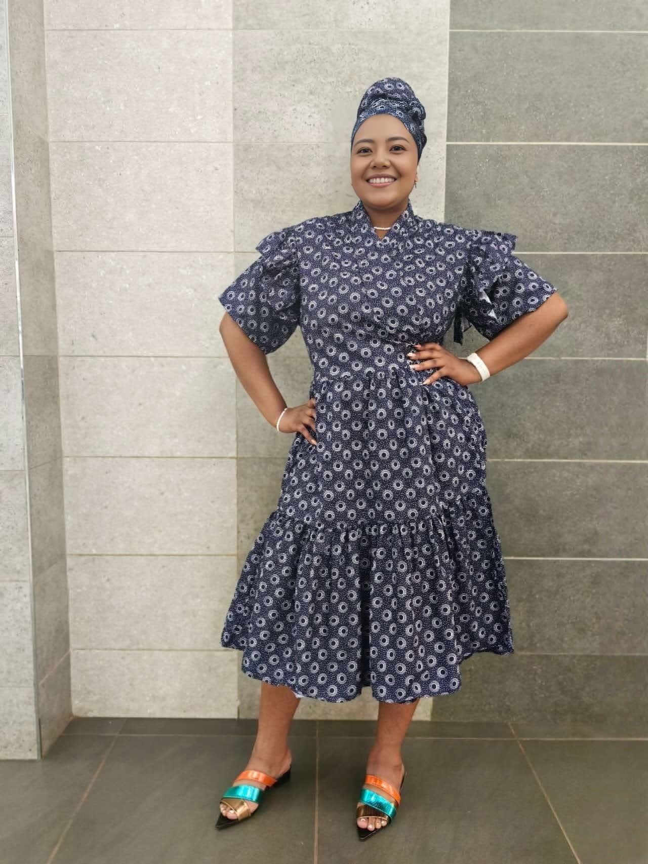 Navy midi dress with short ruffled sleeves and tiered skirt, small white pattern