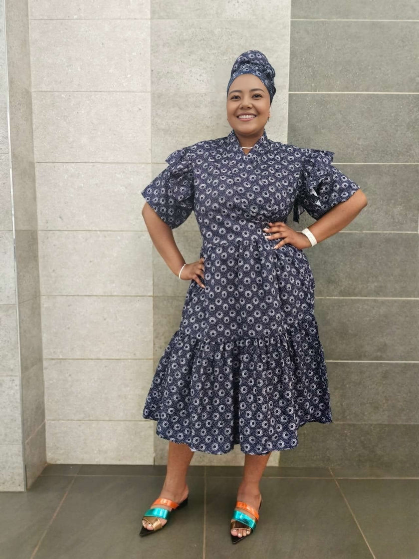 Navy midi dress with short ruffled sleeves and tiered skirt, small white pattern