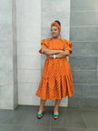 Orange midi dress with short ruffled sleeves and tiered skirt, small allover pattern