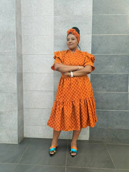 Orange midi dress with short ruffled sleeves and tiered skirt, small allover pattern