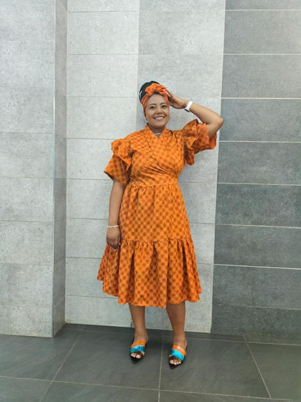 Orange midi dress with short ruffled sleeves and tiered skirt, textured small print