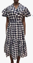White midi dress with navy circular print, ruffle sleeves, and tiered skirt