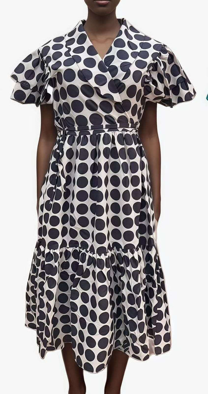 White midi dress with navy circular print, ruffle sleeves, and tiered skirt