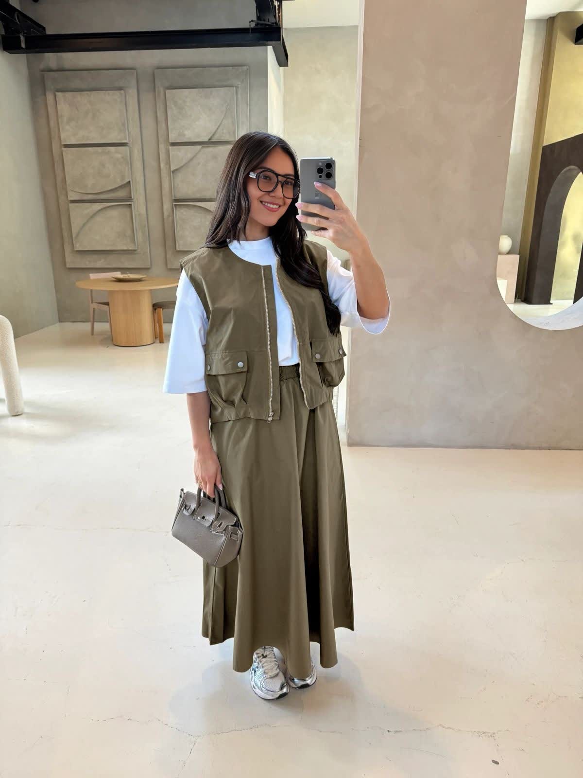 Olive utility vest over white top with matching long maxi skirt