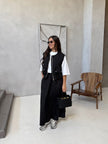 Black utility vest over white top with matching long maxi skirt