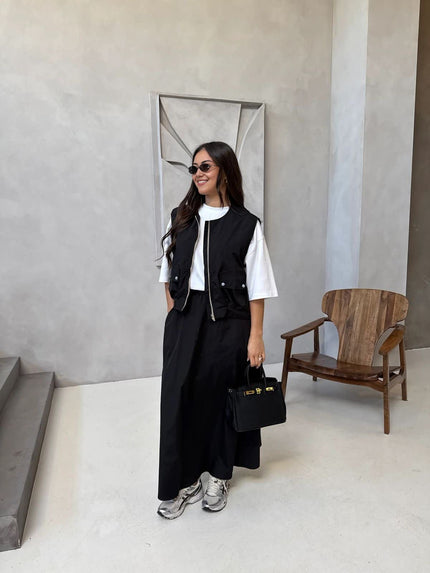 Black twin set: sleeveless utility vest with flap pockets over long maxi skirt