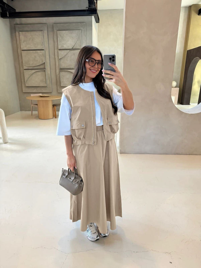 Beige utility vest over white top with matching long maxi skirt