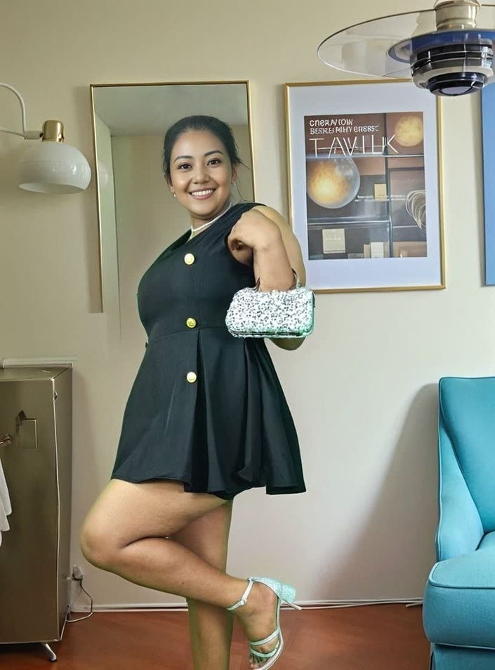 Black double-breasted sleeveless mini dress with gold buttons and flared skirt