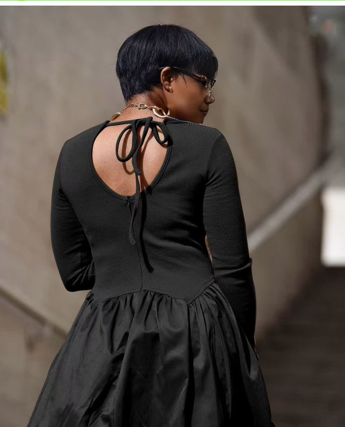Black maxi dress with open back, long sleeves, and gathered A-line skirt