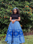 Blue pleated maxi skirt with African print flared panels and patterned hem
