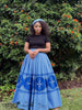 Blue pleated maxi skirt with African print flared panels and patterned hem