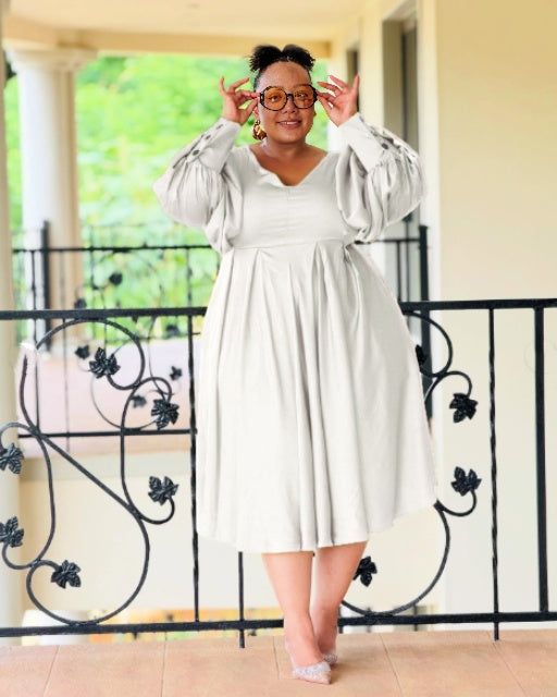 Plus-size midi dress in white with V-neck and puff sleeves, pleated skirt
