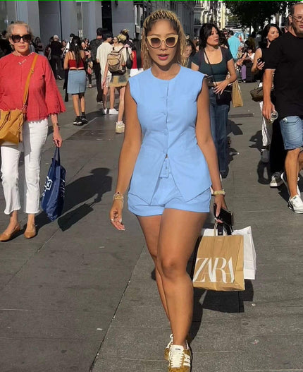 Sky-blue sleeveless front-tie romper with short legs and button-front