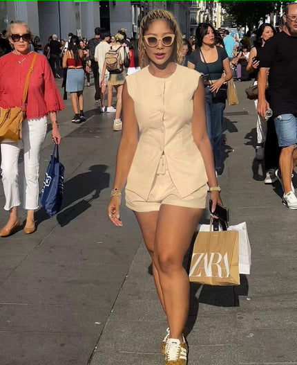 Beige sleeveless front-tie romper with short legs and button-front