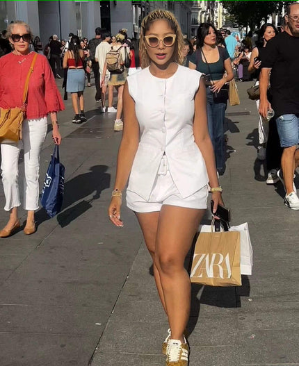 White sleeveless front-tie romper with short legs and button-front