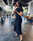 Black knit midi dress with short sleeves and vertical button front with side slit.