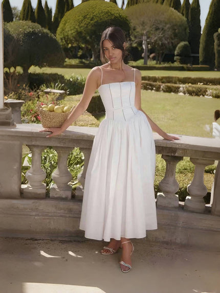 White midi dress with thin straps, fitted bodice and pleated skirt