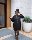 Black midi dress with five gold buttons down the front and long sleeves