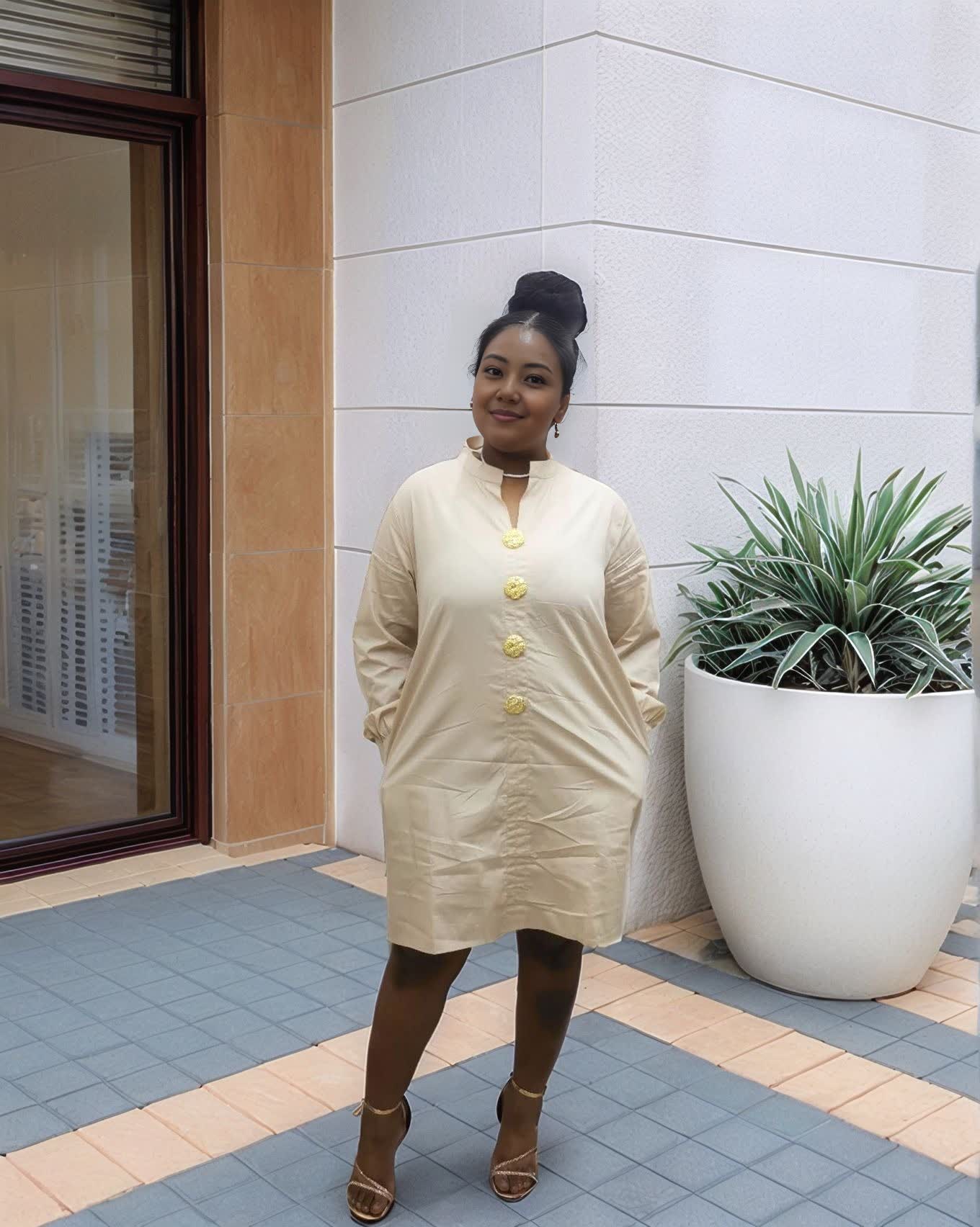 Nude midi dress with five gold buttons at the front and long sleeves