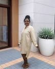 Nude midi dress with five gold buttons down the front and long sleeves