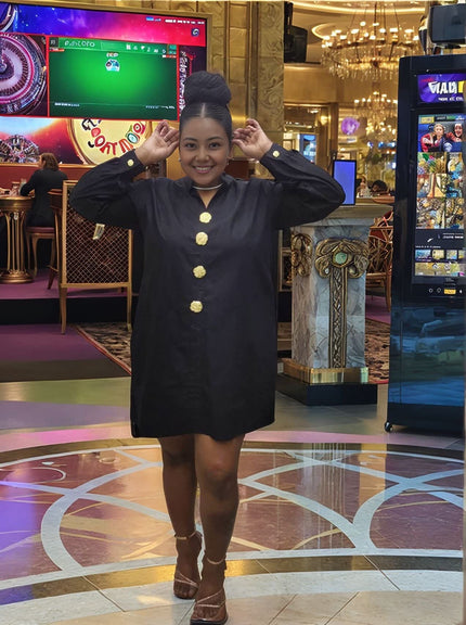 Black midi dress with five gold button placket and long sleeves, short hemline