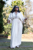 Geometric maxi dress in white with long sleeves, embroidered panel, and tiered skirt