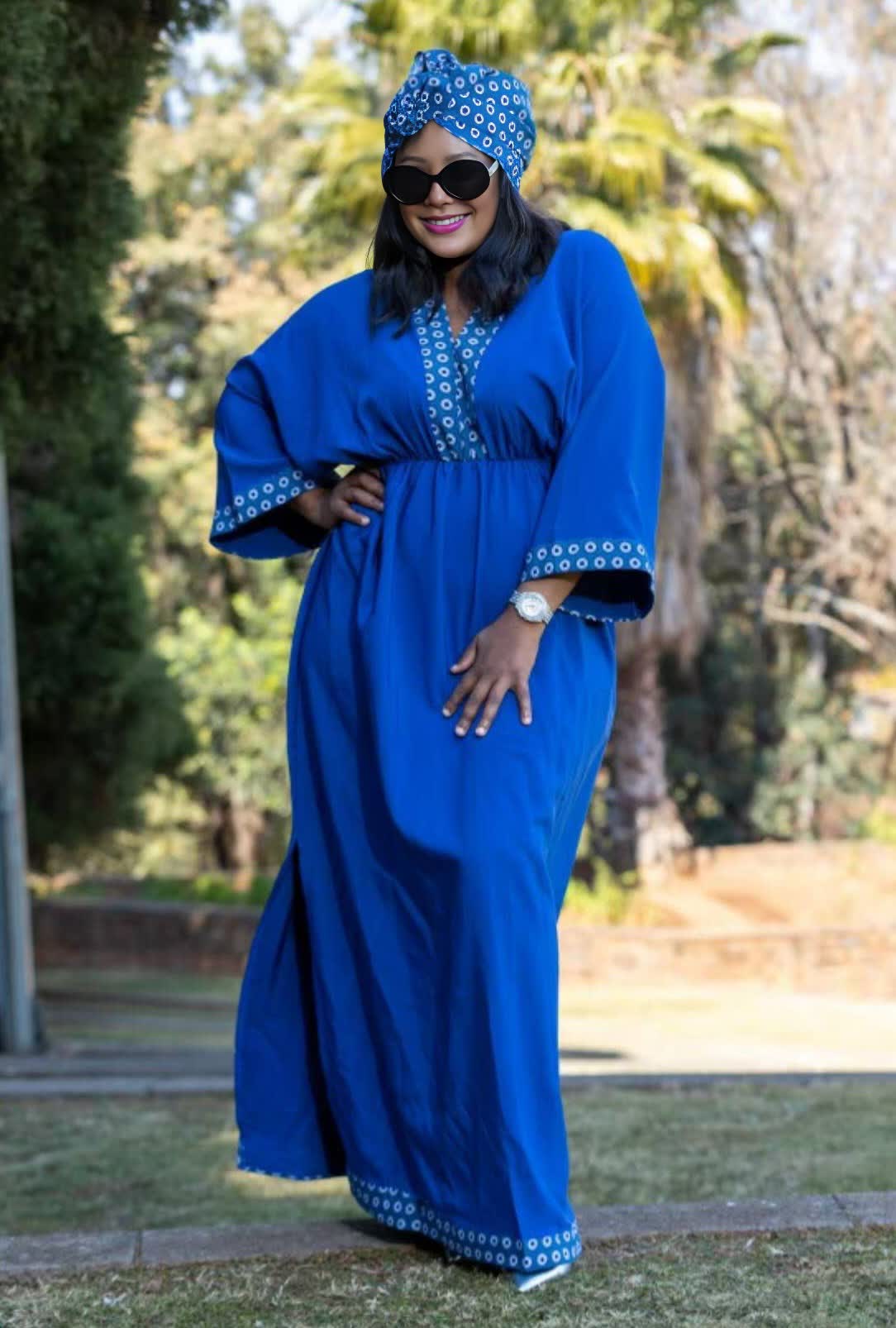 Geometric maxi dress in blue with patterned yoke, wide sleeves, and eyelet hem