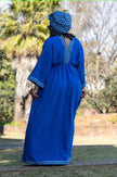 Geometric maxi dress in blue from back view with patterned yoke and eyelet hem