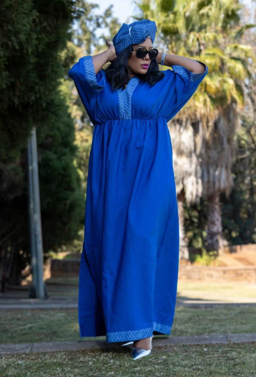 Geometric maxi dress in blue with patterned yoke and decorative cuffs, full-length skirt