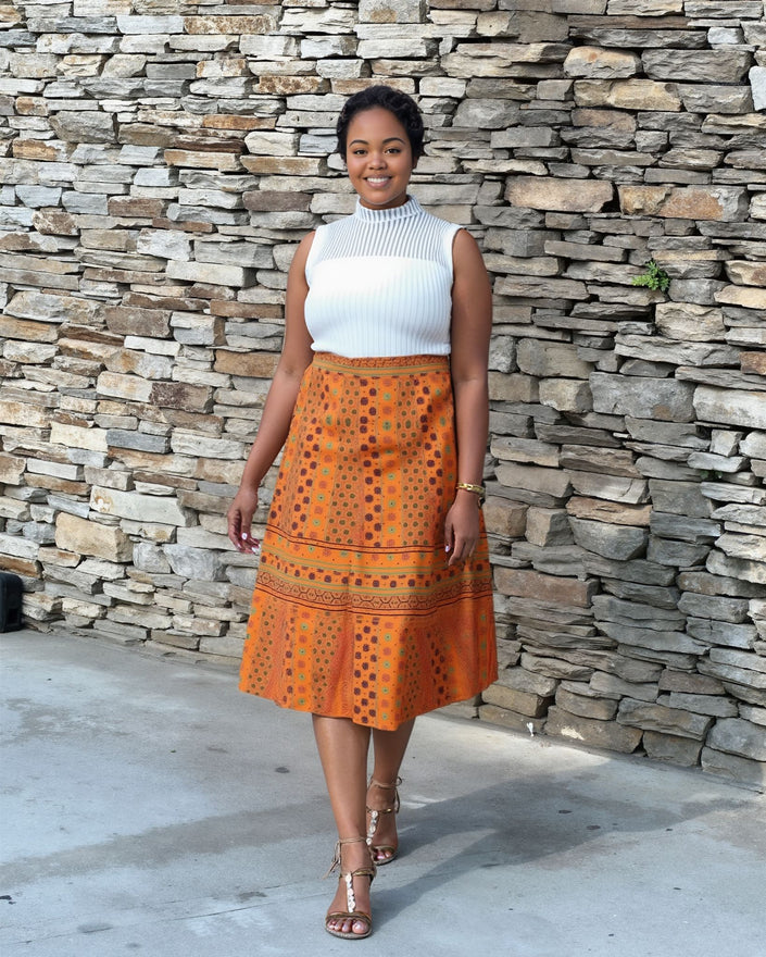 Layered three-piece skirt set with white sleeveless top and orange dotted layered skirt