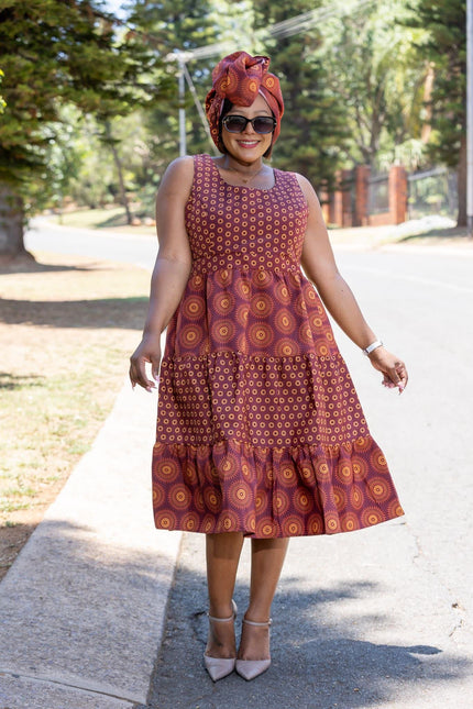 Sleeveless tiered ethnic dress in burgundy with orange geometric motifs