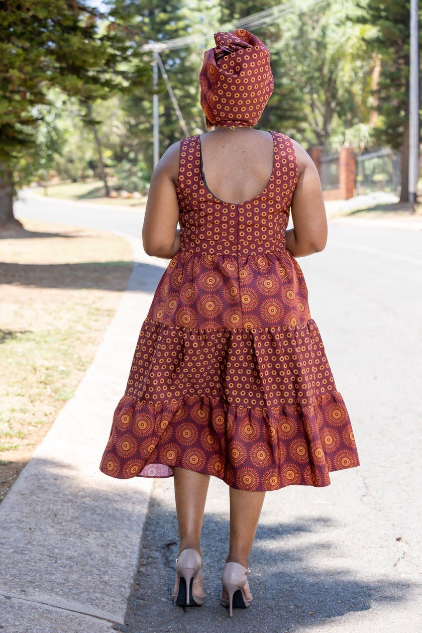 : Traditional Ethnic Sleeveless Tiered Dress with Geometric Patterns and Circular Motifs