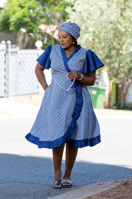 Blue patterned wrap midi dress with ruffle sleeves, ruffled hem, and waist tie