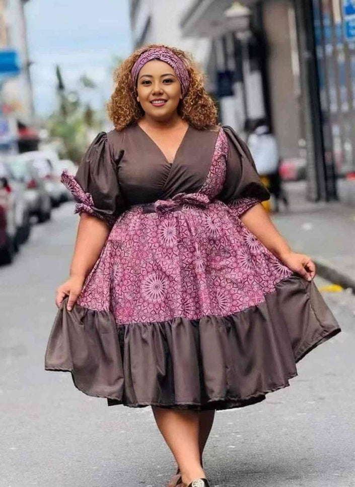 Purple and dark midi dress with puff sleeves, gathered skirt, and V-neck bodice.
