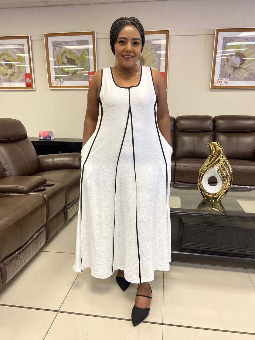 White sleeveless A-line maxi dress with black-trim vertical seam detail and pockets