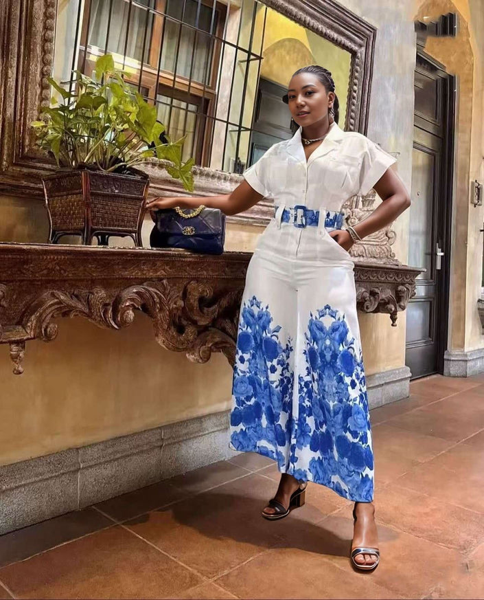 Belted floral wide-leg jumpsuit with blue blooms on white, short sleeves and button front