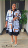 Plus size shirt dress in black with geometric orange and white print, collared midi