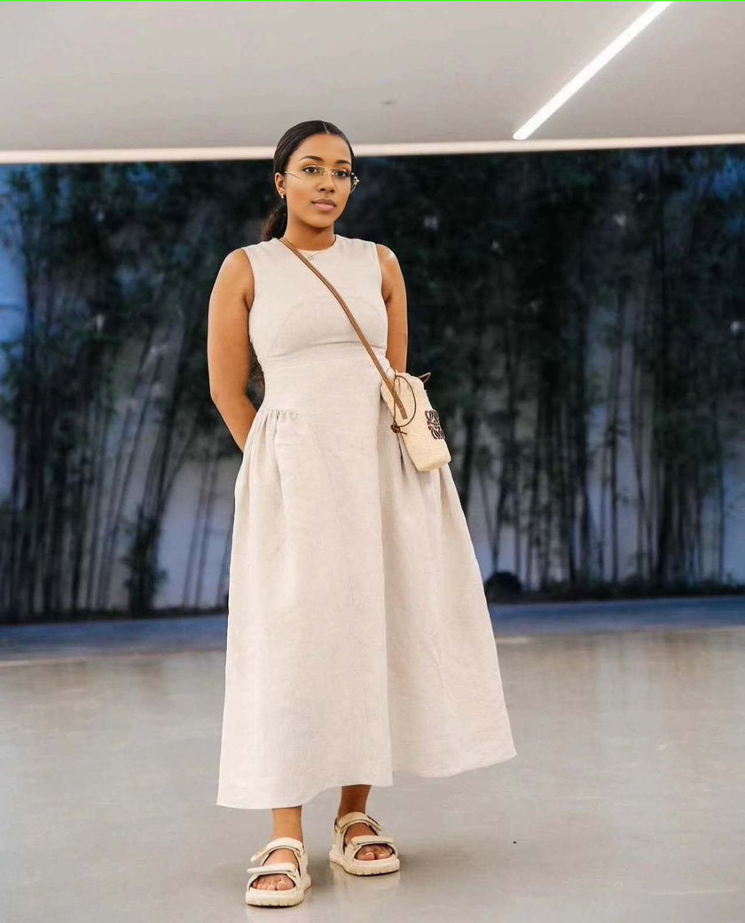 Beige sleeveless maxi dress with pleated waist, round neckline and A-line skirt