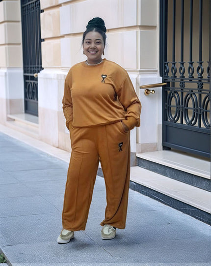 Orange-red loose-fit jogger set with sweatshirt and joggers, small cat logo on pants
