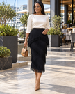 Black layered midi skirt with diagonal fringe panels and a fringed hem