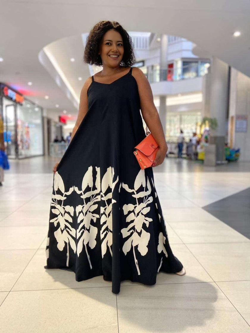 Black tropical print maxi dress with sleeveless square neckline and loose flowing skirt