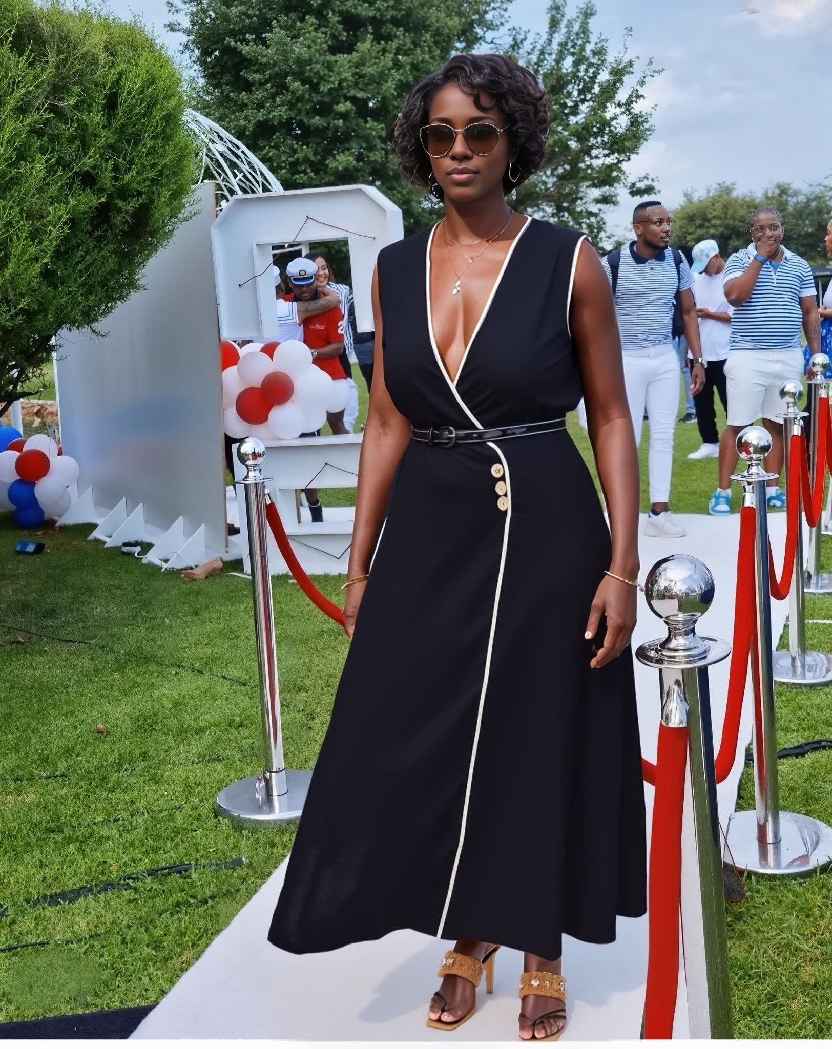 Black sleeveless V-neck midi dress with button accents and waist belt