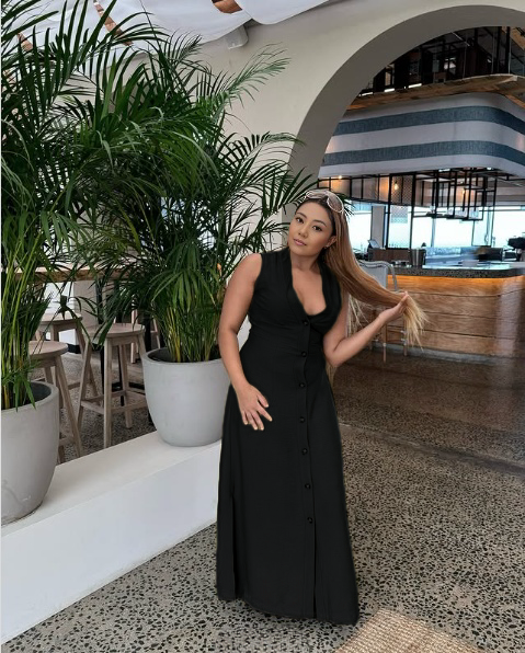 Black sleeveless V-neck midi dress with button-down front and sleeveless fitted silhouette