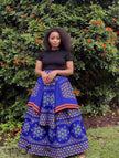 Blue African print maxi skirt with floral motifs and orange trim, full gathered flare.