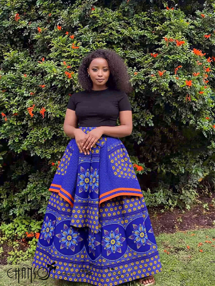 Blue African print maxi skirt with floral motifs and orange trim, full gathered flare.