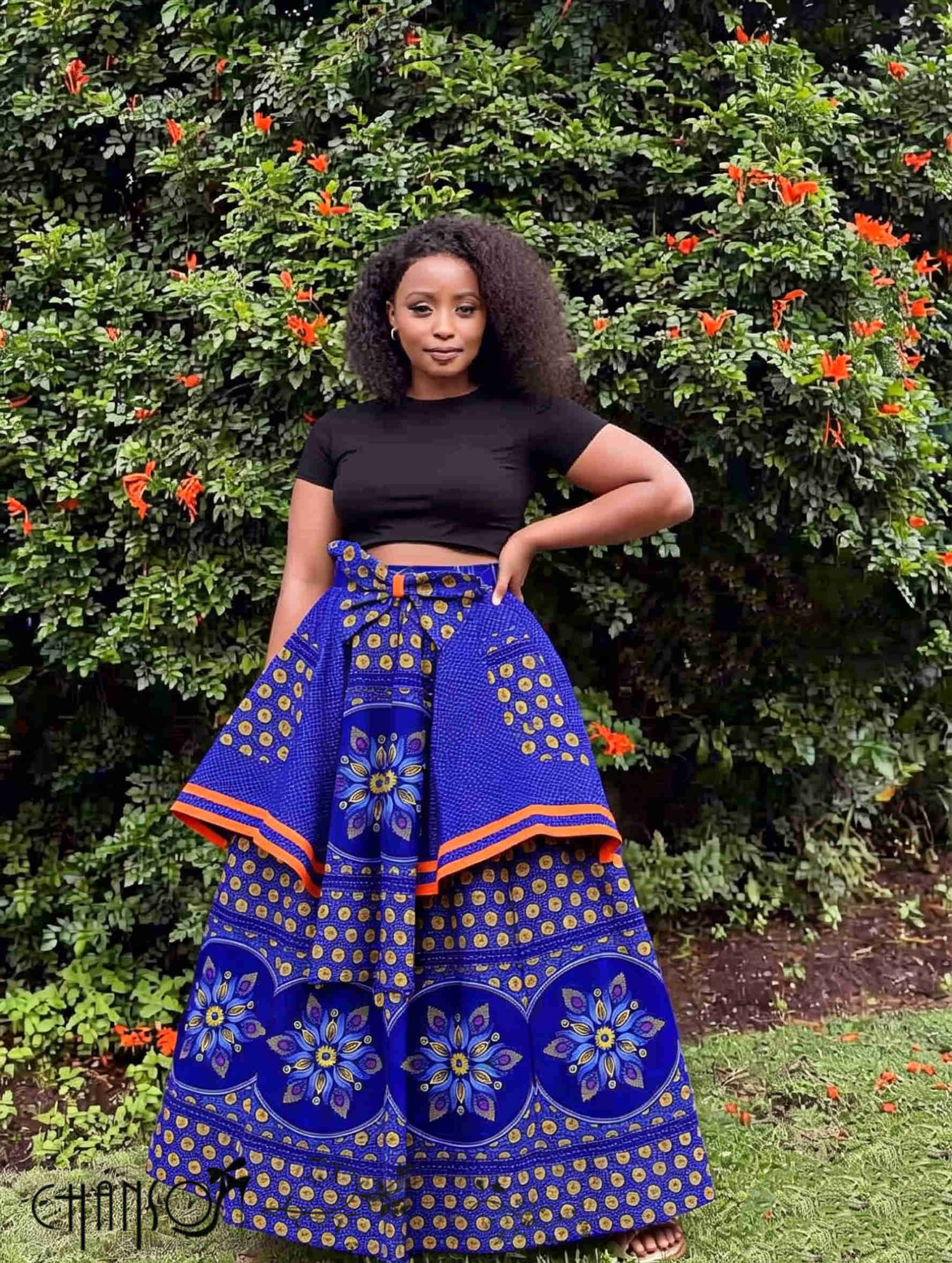 Blue African print maxi skirt with floral medallion print, orange trim, tied waistband.