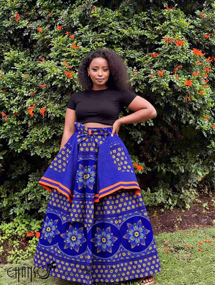 Blue African print maxi skirt with floral medallion print, orange trim, tied waistband.